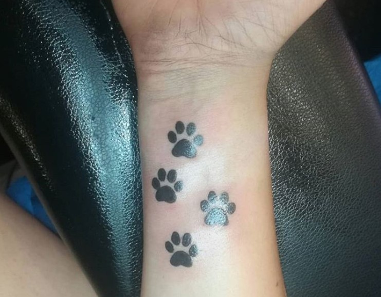 four simple paw print tattoo on wrist