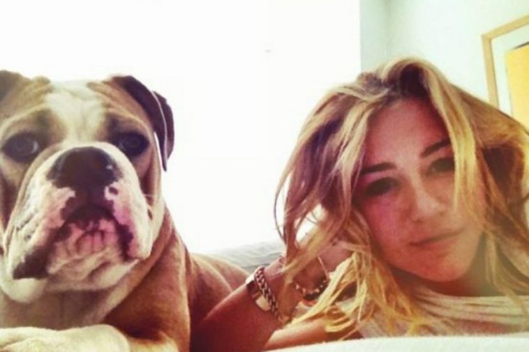 Miley Cyrus on the bed with her English Bulldog