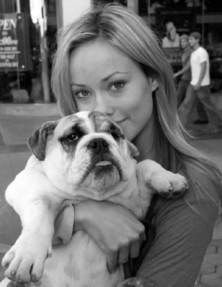 Olivia Wilde kissing her English Bulldog while holding it in her arms