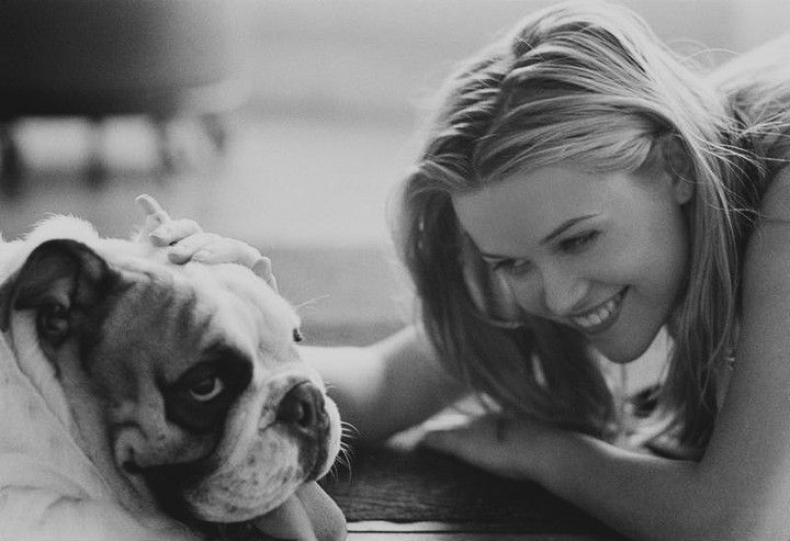 black and white photo of Reese Witherspoon petting her English Bulldog