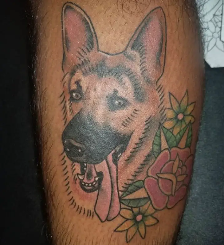 face of German Shepherd dog with its tongue sticking out and flowers on its side tattoo on the leg