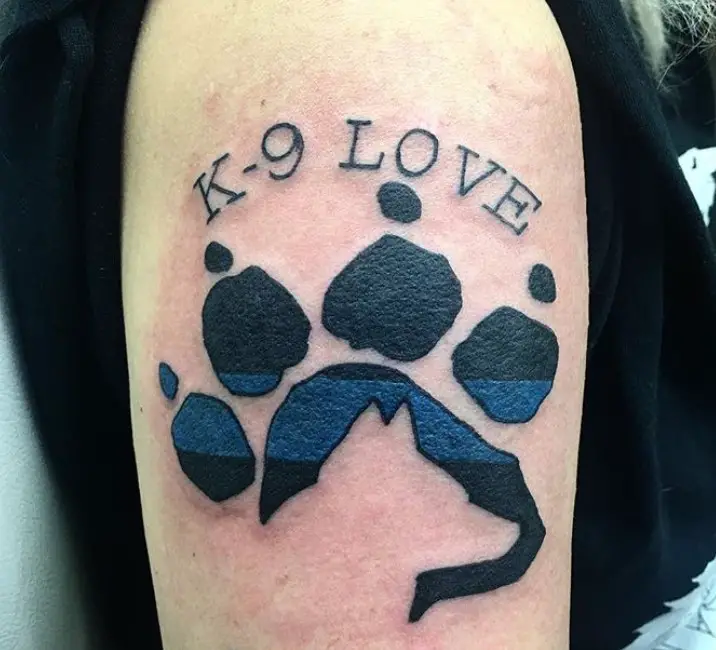 paw print with written K-9 Love on top of it tattoo on the shoulder