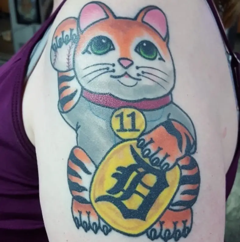 A colored Lucky Cat Tattoo on the shoulder of a woman