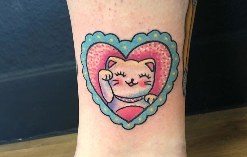 A cute white Lucky Cat inside a heart frame Tattoo on the leg