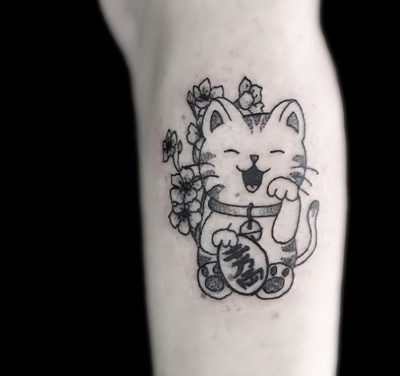 A black and white Lucky Cat Tattoo on the leg