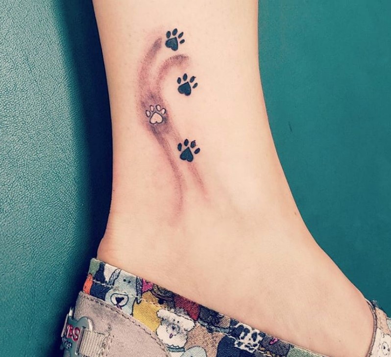 small paw prints tattoo on the ankle