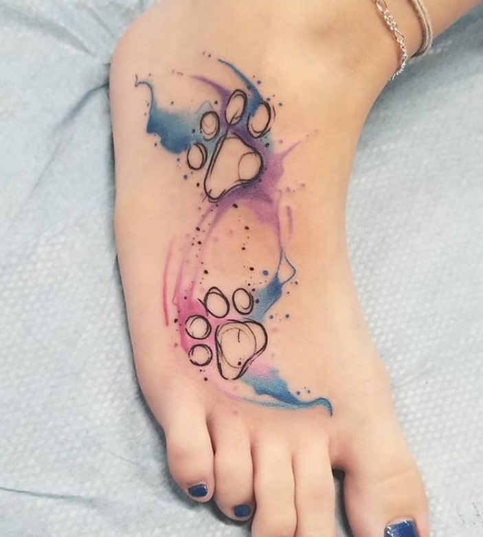 outline paw print with watercolor design tattoo on feet