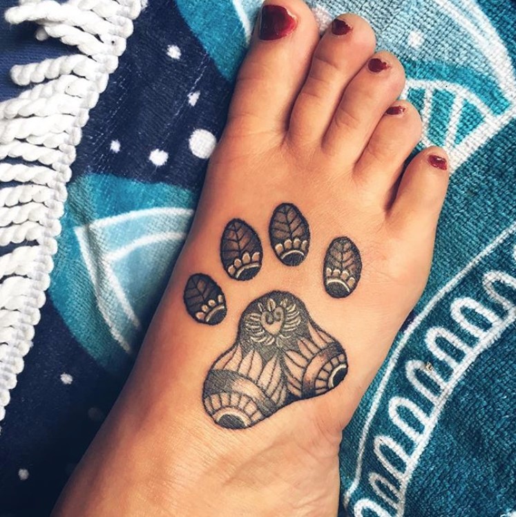 mandala design in paw print tattoo on the feet