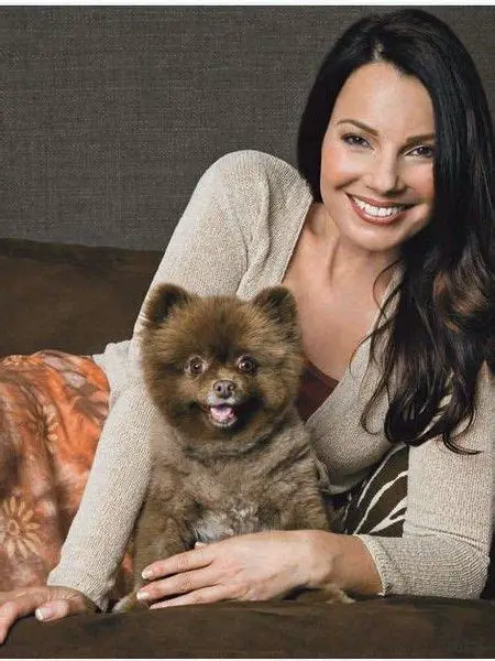 Fran Drescher lying on the couch with her Pomeranian