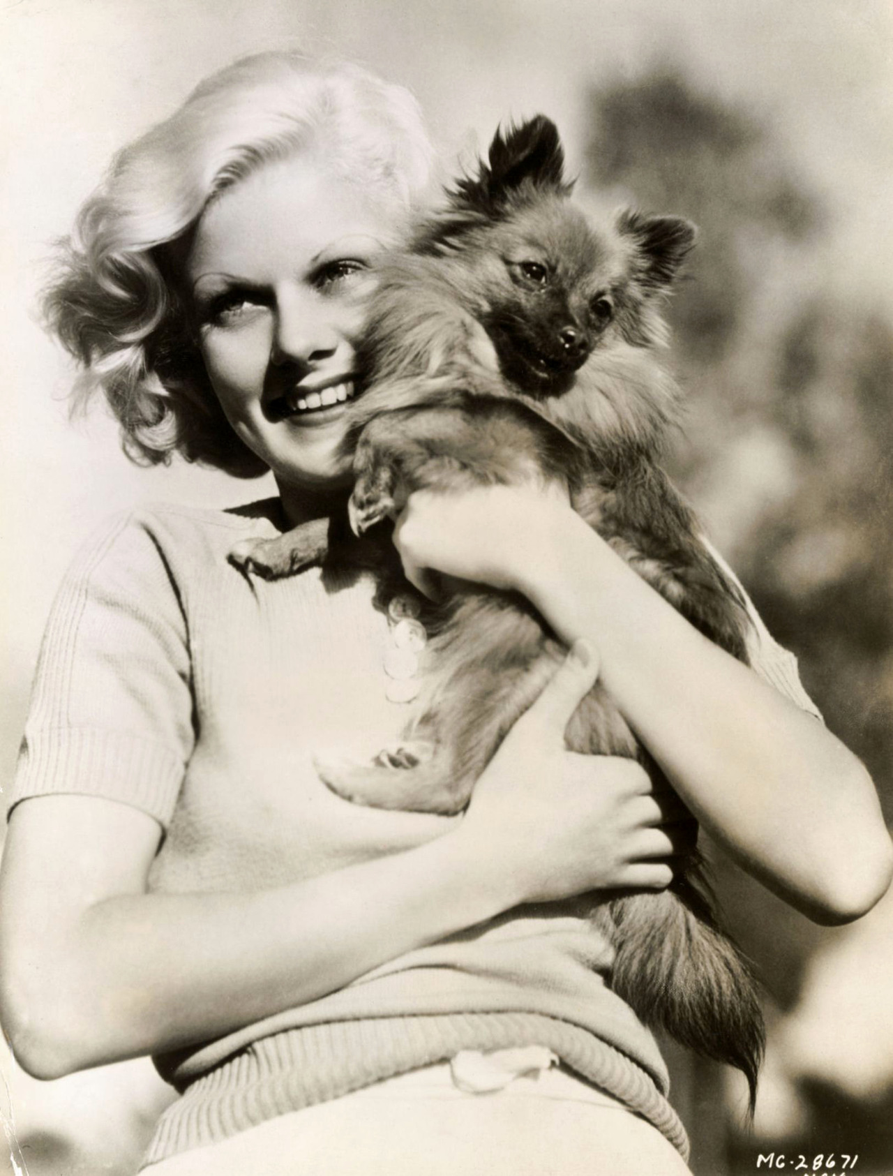 Jean Harlow hugging her pomeranian