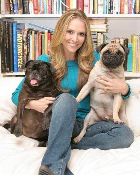 Brooke Mueller sitting on the couch with her two pugs beside her