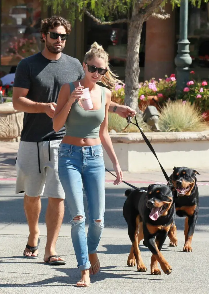 Brody Jenner walking in the street with his two Rottweilers on a leash
