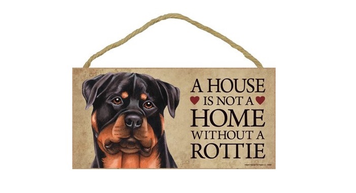 A wooden sign with the face of a Rottweiler and with saying - A house is not a home without a Rottie