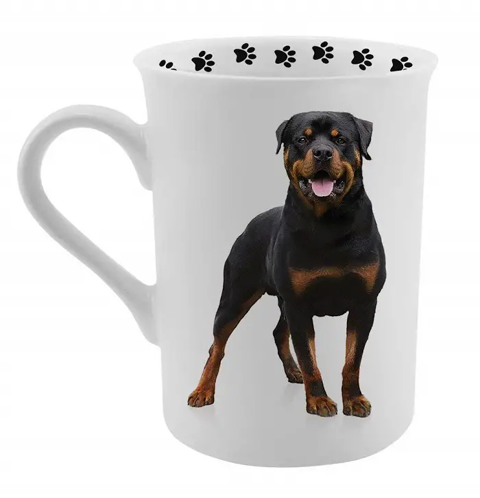 A white coffee mug printed with Rottweiler and paw prints