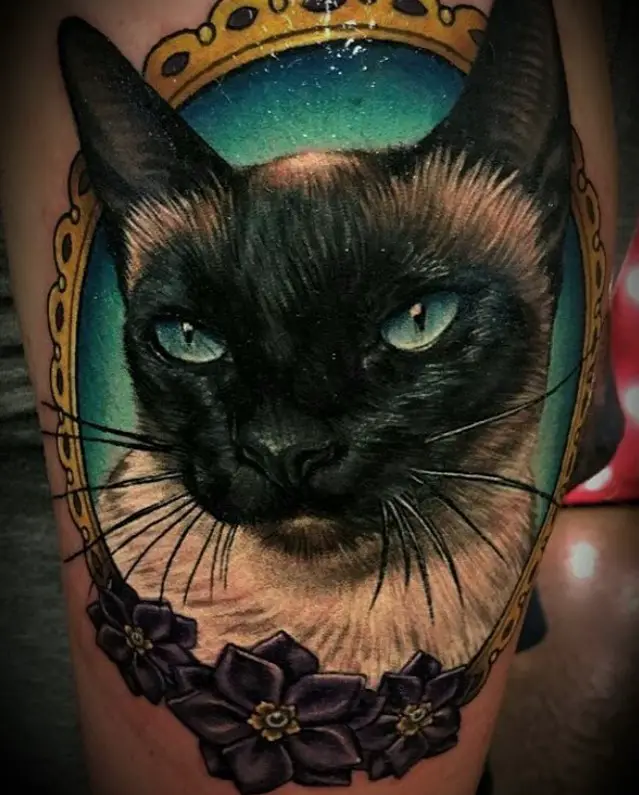 realistic face of a Siamese Cat in a vintage gold frame tattoo