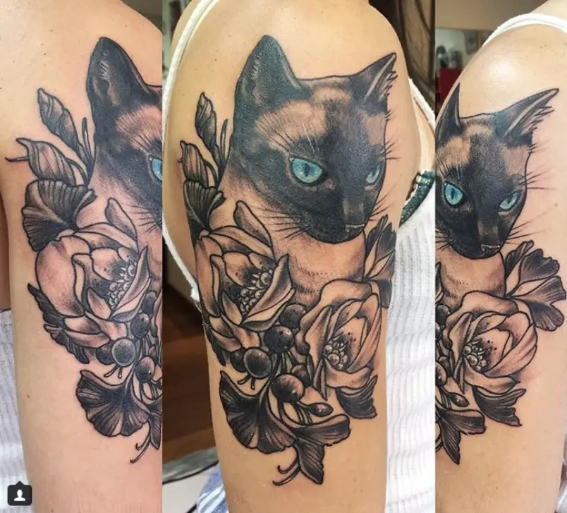 Siamese Cat on top of flowers tattoo on the shoulder of a woman