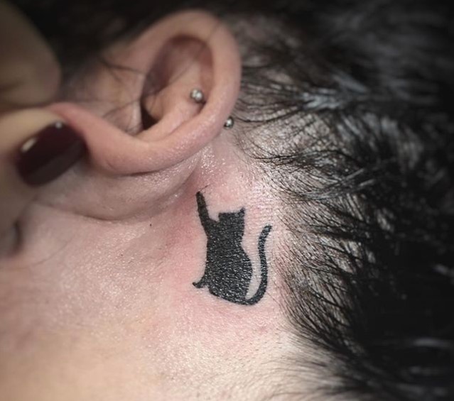 black cat tattoo at the back of the ear