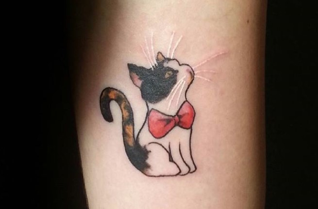 sitting cat wearing a red ribbon on its neck tattoo on the forearm