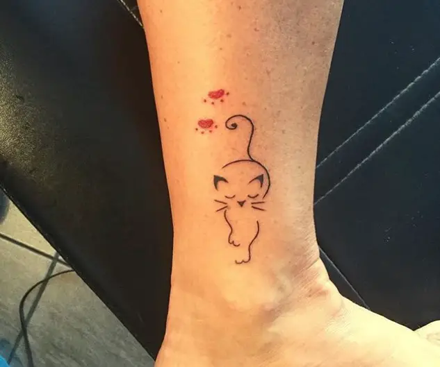 outline of a walking chic cat with two red paws tattoo on the ankle
