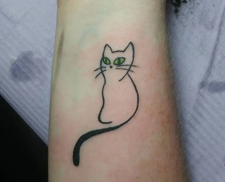 outline of a cat with green eyes tattoo on the forearm