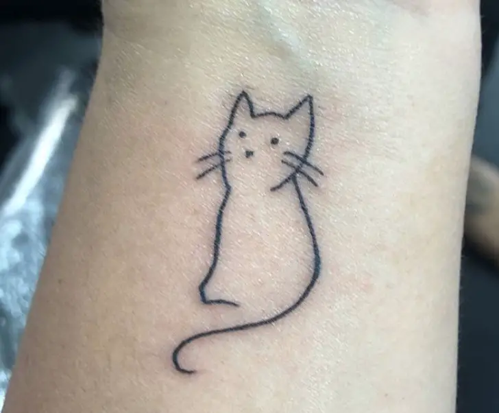outline of a sitting cat tattoo on the wrist