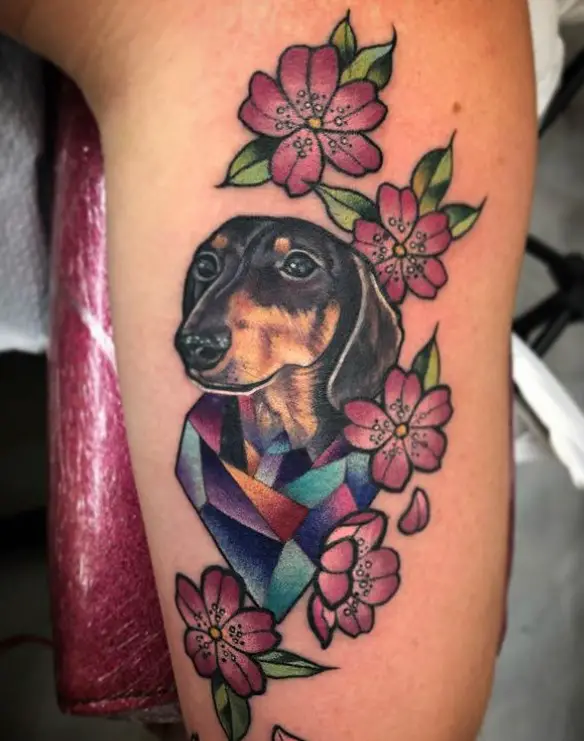 realistic Wiener Dog in a colorful geometric and pink flowers around her tattoo on the leg