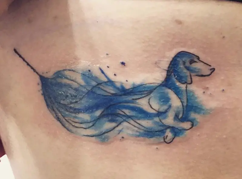 blue smoky Wiener Dog coming out from a flower tattoo