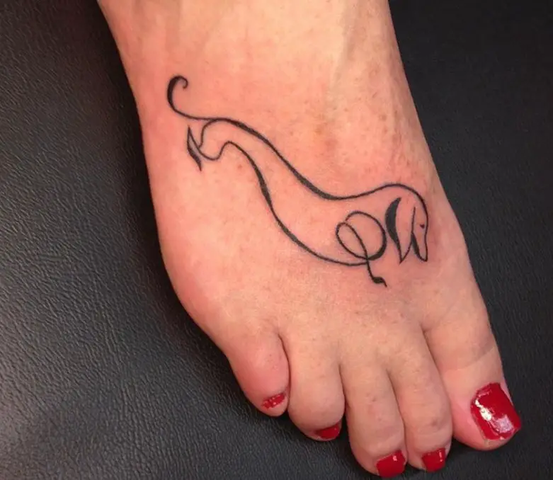 outline of a Wiener Dog tattoo on foot with red nails