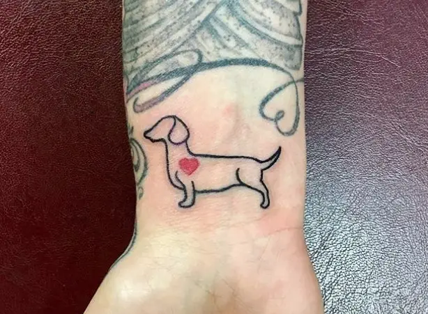 outline of a Wiener Dog standing sideways tattoo on the wrist