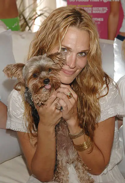 Molly Sims holding her Yorkshire Terrier who is sticking her tongue out