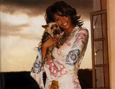 Whitney Houston holding closely her Yorkshire Terrier