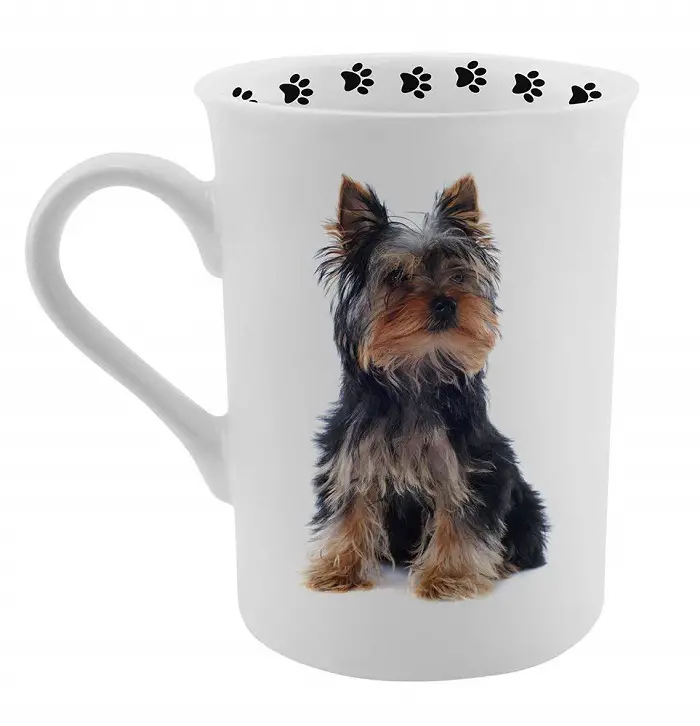 A white mug printed with Yorkshire Terrier and paw prints