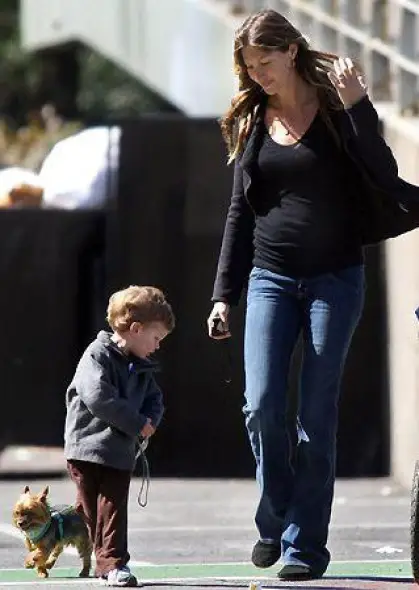GISELE BUNDCHEN with his kid walking a Yorkshire Terrier in the street