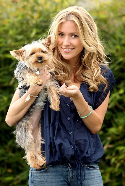 KRISTIN CAVALLARI carrying her smiling Yorkshire Terrier