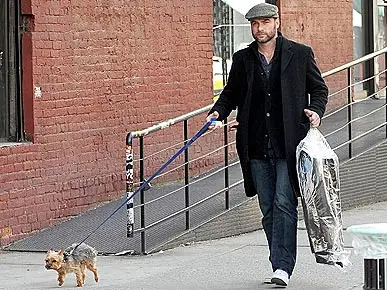 LIEV SCHREIBER walking in the street with his Yorkshire Terrier