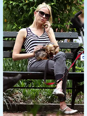 NAOMI WATTS sitting on the bench at the park with her Yorkshire Terrier in her lap