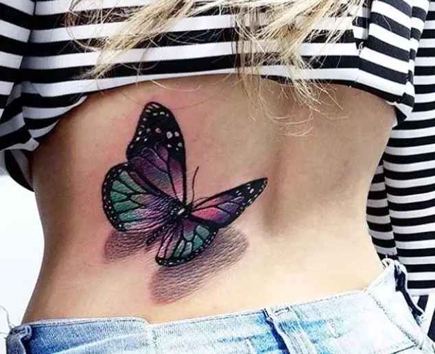 Vibrant colored butterfly tattoo on lower back.
