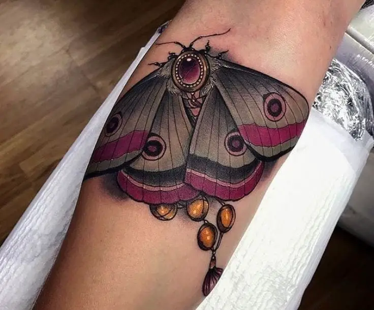 black and purple colored butterfly tattoo on arm
