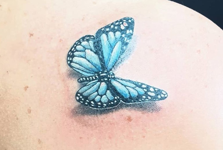 Blue 3D butterfly tattoo on shoulder