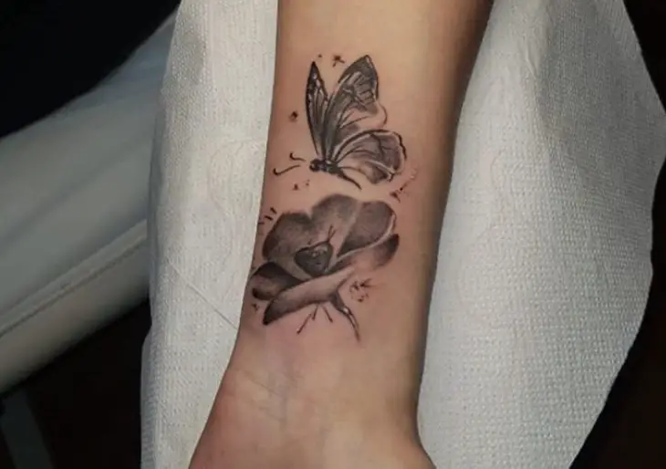 Shaded butterfly and flower tattoo on wrist.