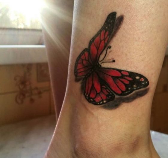 Red butterfly tattoo on the ankle