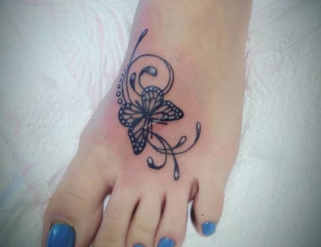 Black butterfly tattoo on feet.