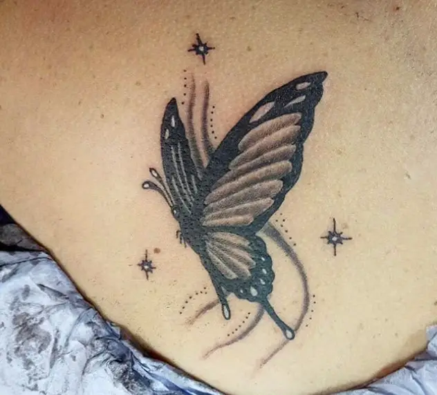 Black Butterfly with stars around tattoo