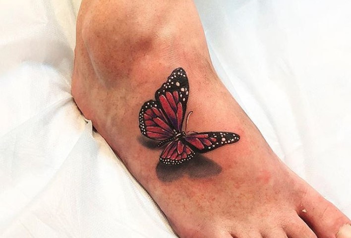 Red realistic butterfly tattoo on feet