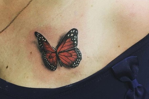 Red 3D butterfly tattoo on chest