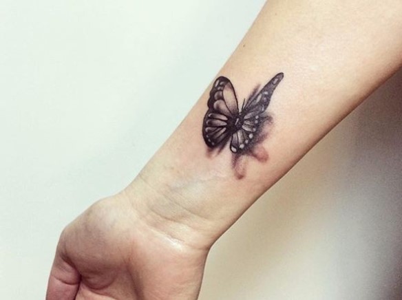 Black 3D butterfly tattoo on wrist