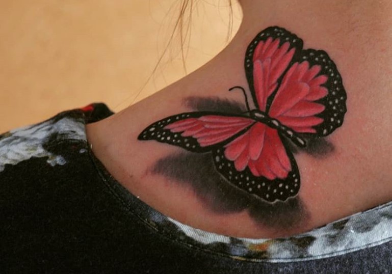 Red butterfly tattoo on shoulder