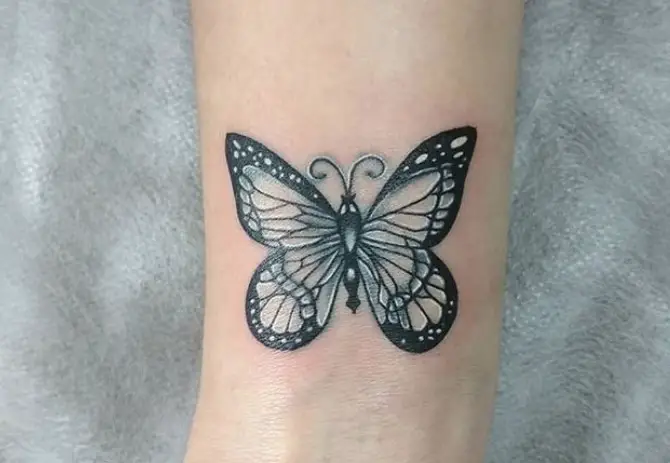 Black and white butterfly tattoo on wrist