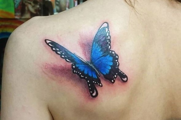 Blue 3D butterfly tattoo on shoulder