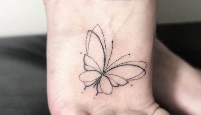 Minimalist outline butterfly tattoo on feet